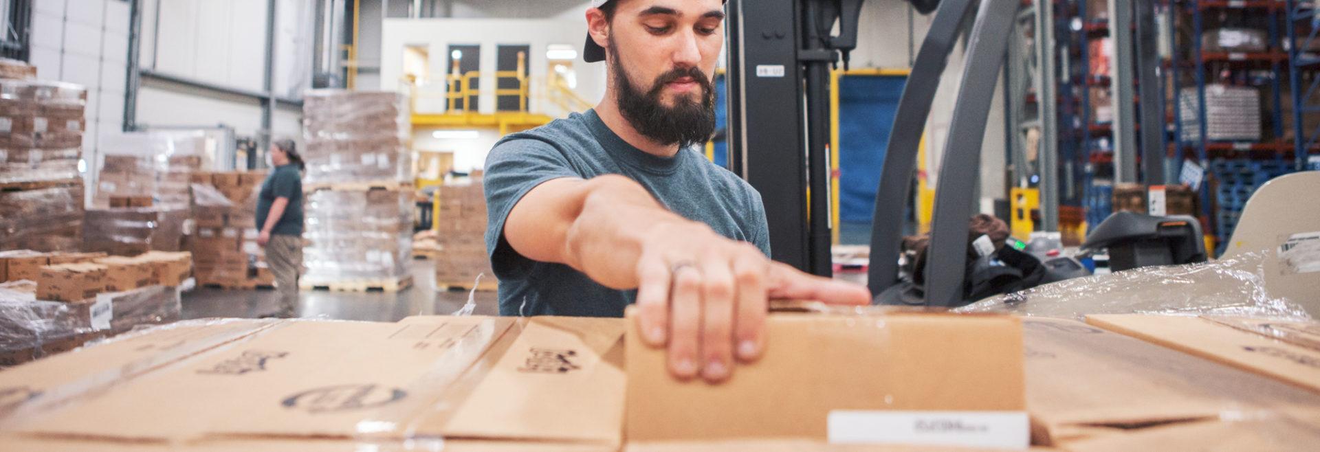 man pulling a box in a warehouse
